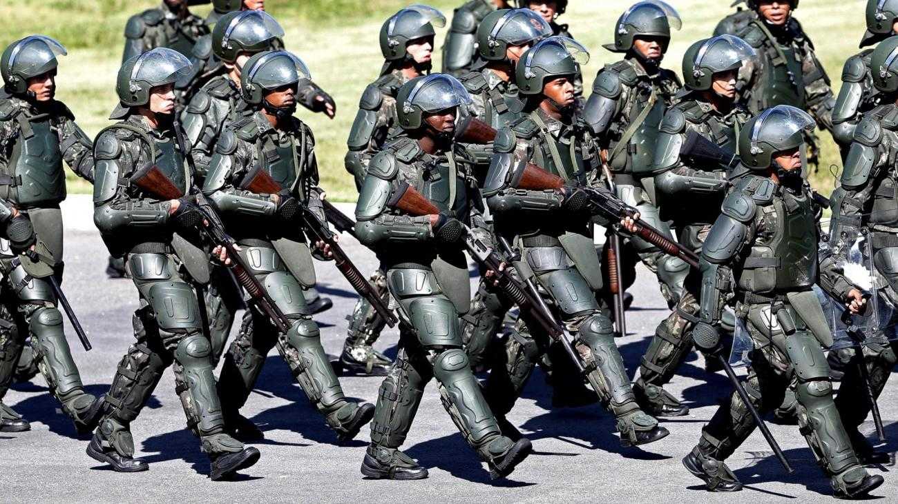 A large number of heavily armoured police, with guns, march in Brazil