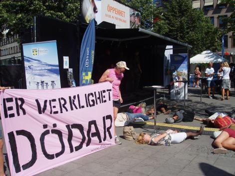 Die-in in Pride Park, Stockholm, 2001. The banner says 'Your reality kills' (credit - Ofog)