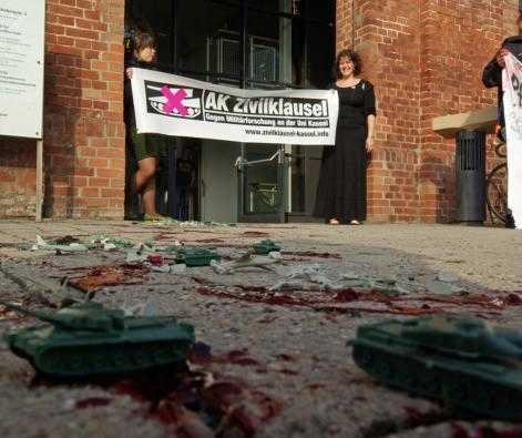 A protest - with toy tanks, planes, soldiers and fake blood strewn on the floor - calling for the demilitarisation of Kassel University, May 2012 (credit - Michael Schulze von Glaßer)