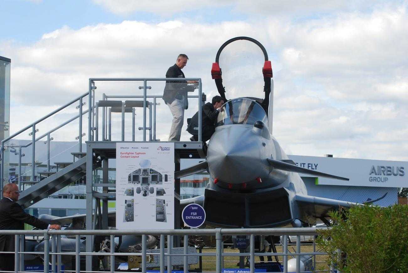 Two men inspect a plane at Farnborough International