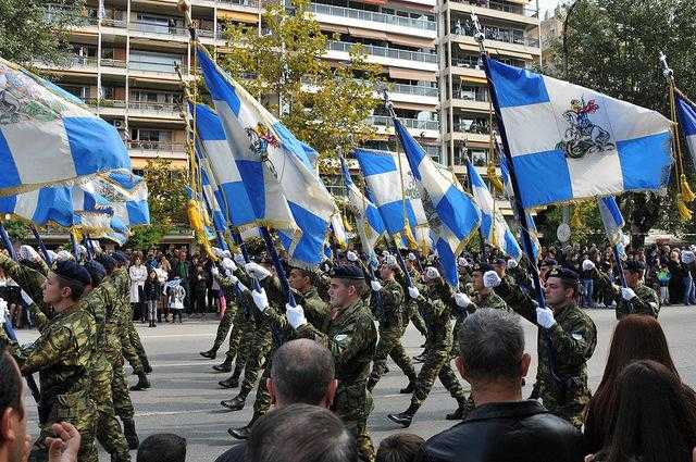 Soldats grecs marchant avec des drapeaux bleus et blancs