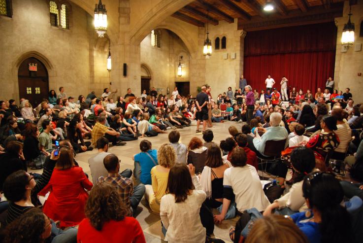 A large group of people take part in a forum theatre exercise