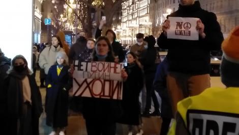Varias personas participan en una protesta en Rusia. Llevan carteles que dicen "no a la guerra"