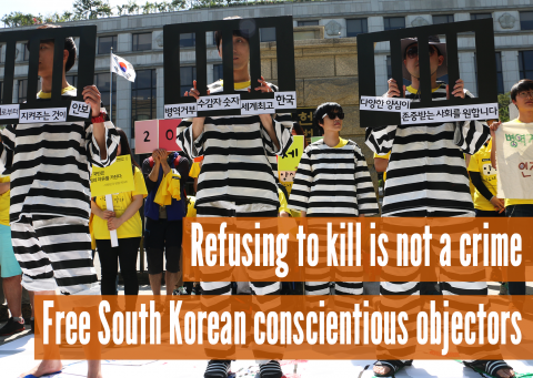 South Korean activists protest wearing black and white "jail" uniforms