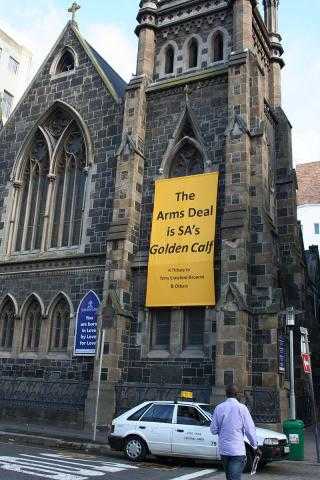 A banner outside a church in South Africa reads "The Arms Deal is South Africa's Golden Calf"