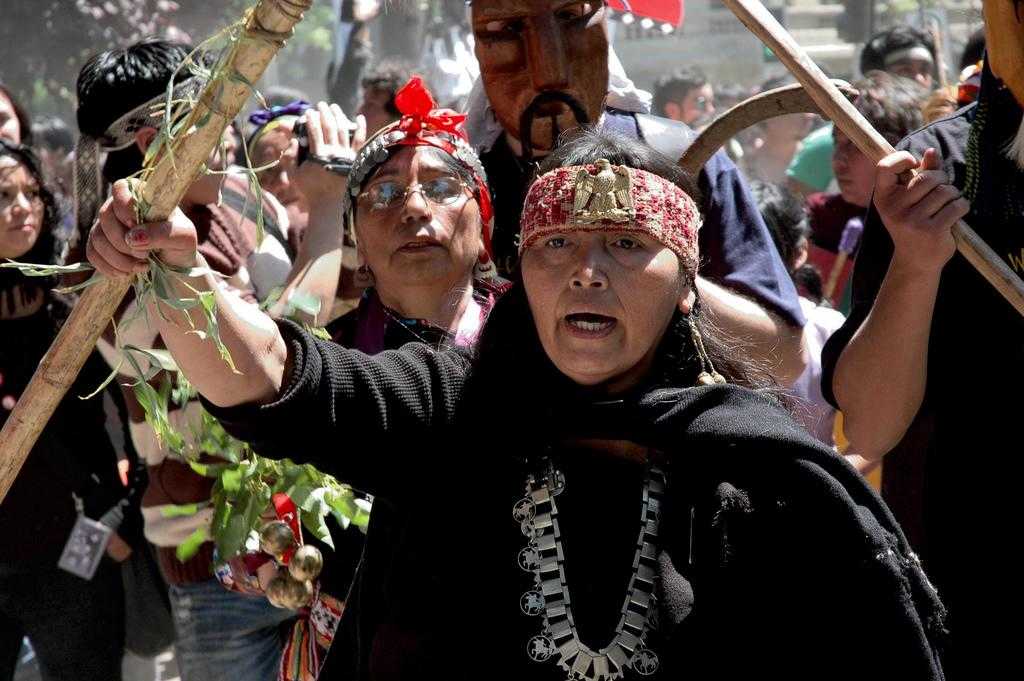 Manifestation du peuple Mapuche à l’un des anniversaires de la prétendue découverte des Amériques, pour dénoncer la répression qu’il subit de la part de l’État chilien et  les bavures de la poliManifestation du peuple Mapuche à l’un des anniversaires de la prétendue découverte des Amériques, pour dénoncer la répression qu’il subit de la part de l’État chilien et  les bavures de la police. Crédit photo : antitezo (flickr). Publié sous licence Creative Commons BY-NC-SA 2.0Un tramo de una manifestación mapuche