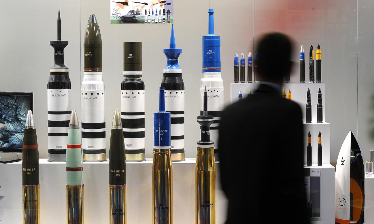 A man looks at a large range of missiles at the DSEI arms fair.