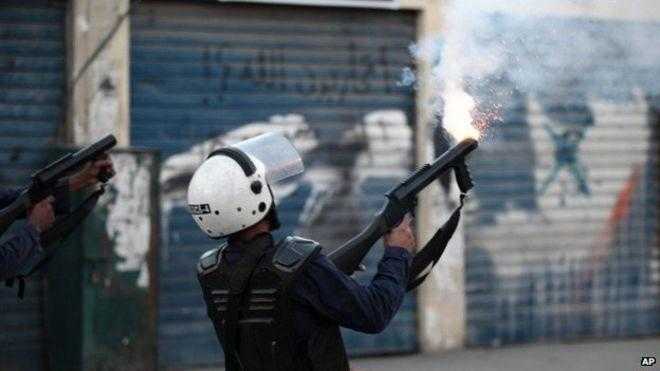 A Bahraini police officer fires tear gas