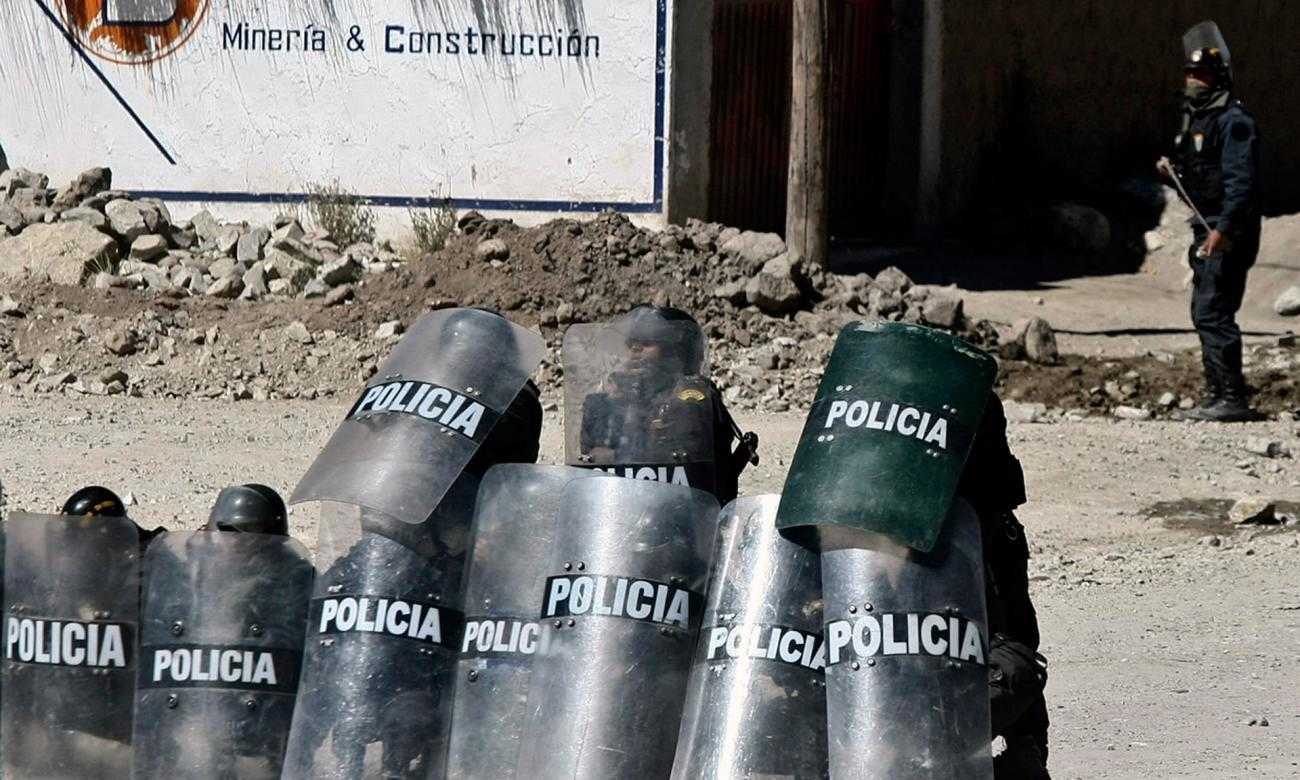 Policías sosteniendo escudos frente a la mina Tintaya en Perú