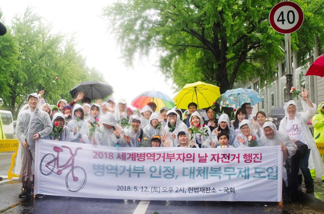 Activists in South Korea holding umbrellas and a banner