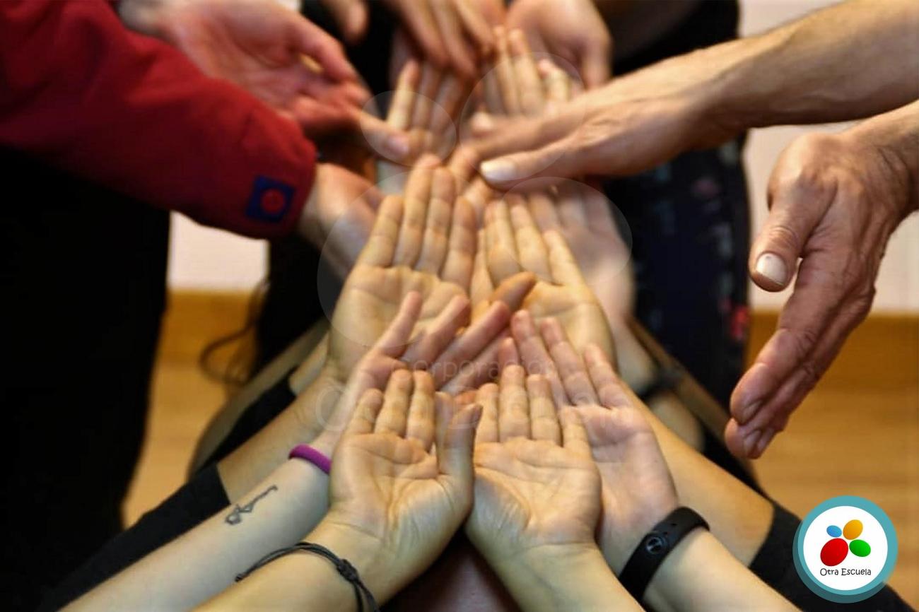 Una fotografía que muestra manos de personas palmas arriba formando una figura