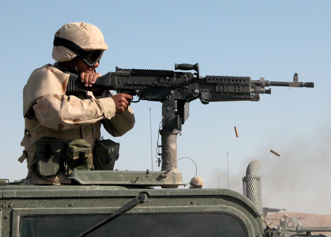 A soldier fires a vehicle mounted machine gun