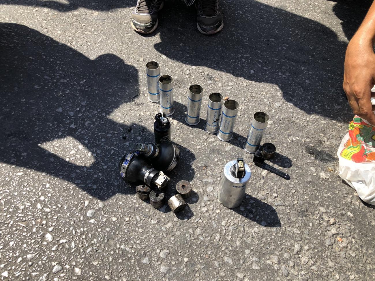 Around a dozen spent tear gas canisters and grenades displayed on the street