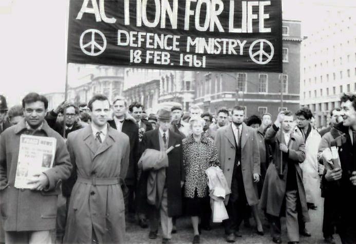 Una foto en blanco y negro que muestra a una multitud de personas que llevan una pancarta que dice "Acción por la vida"