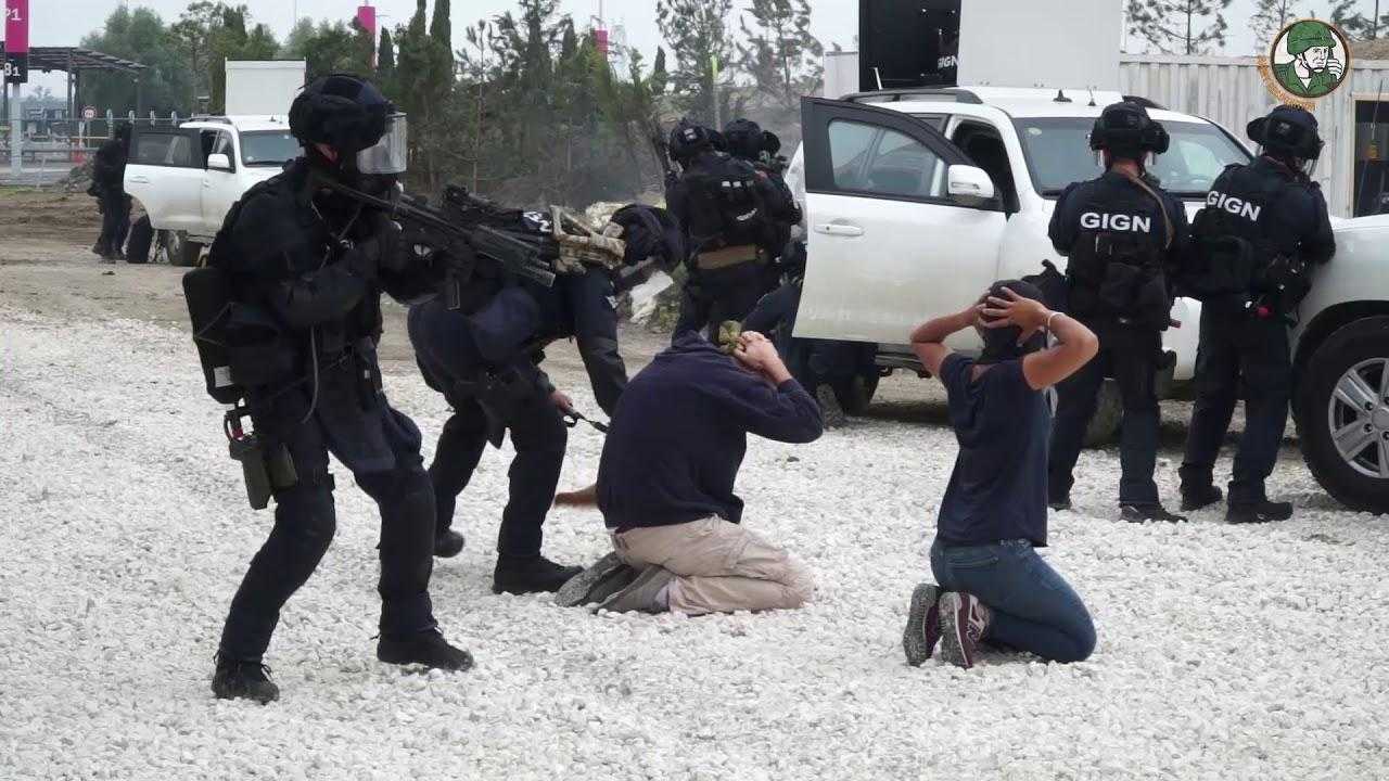 French police take part in a live demonstration at Eurosatory. Heavily armed police officers stand around two men knelt on the floor with their hands on their heads.