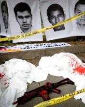 Images from those killed or dissappeared in Mexico. A toy gun covered in blood is in the foreground, and "crime scene" tape is draped across.