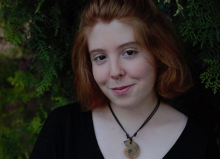 A photo of Marta. She has short ginger hair and is wearing a necklace.