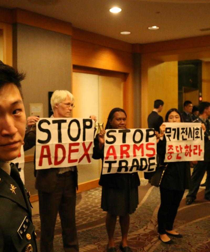 International activists inside the arms dealers welcome dinner at ADEX 2015 in Seoul