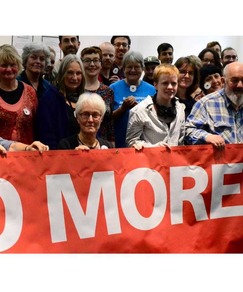 People holding a banner saying 'No more war'