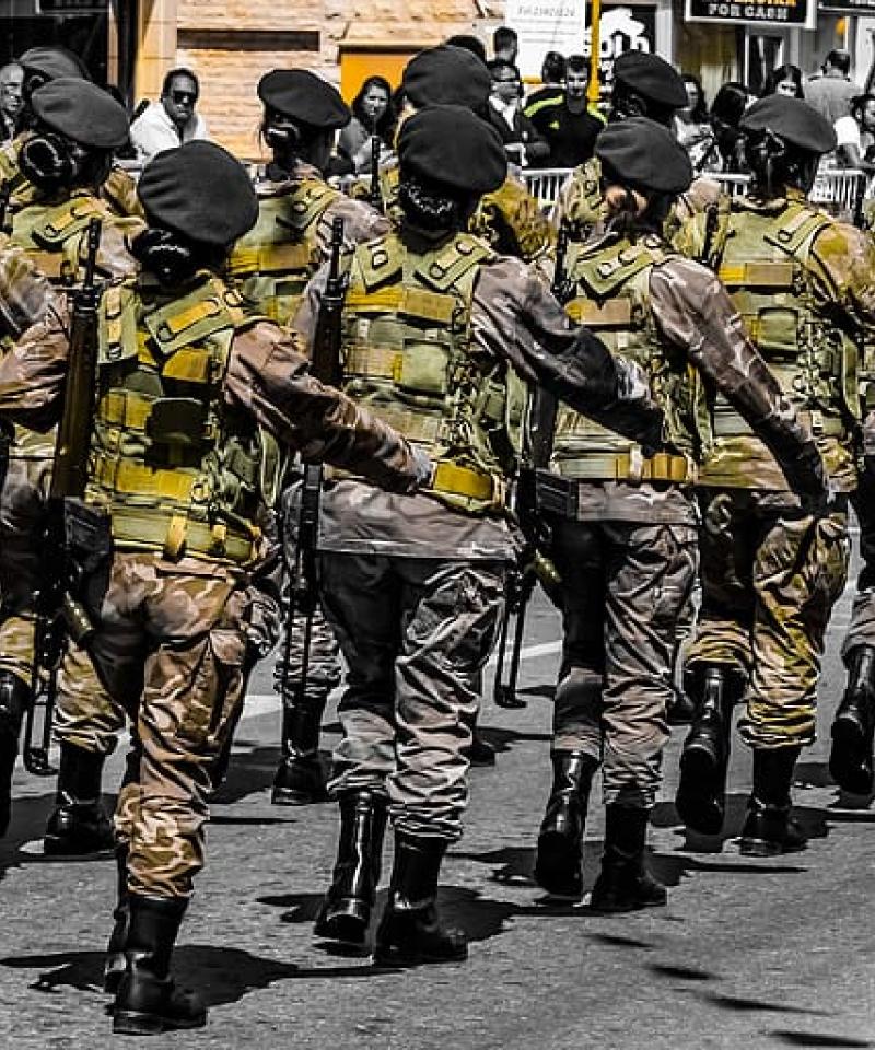 Mujeres marchando vistiendo uniformes militares