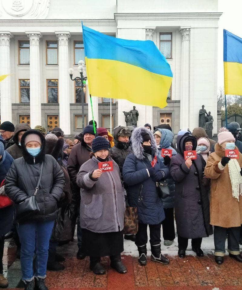 A large group of protesters stand with Ukrainian flags