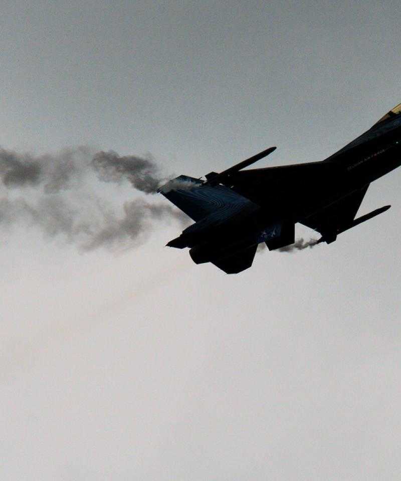 An F16 fighter jet sillhouetted against the sky