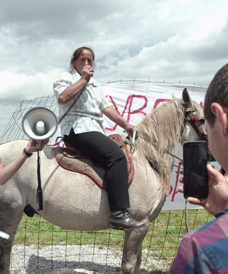 La gente participa en una protesta en Sinjajevina. Un participante va a caballo.
