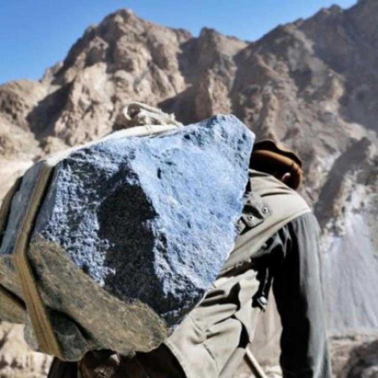 A man carries a large piece of lapis, a semi-precious stone, in Afghanistan.