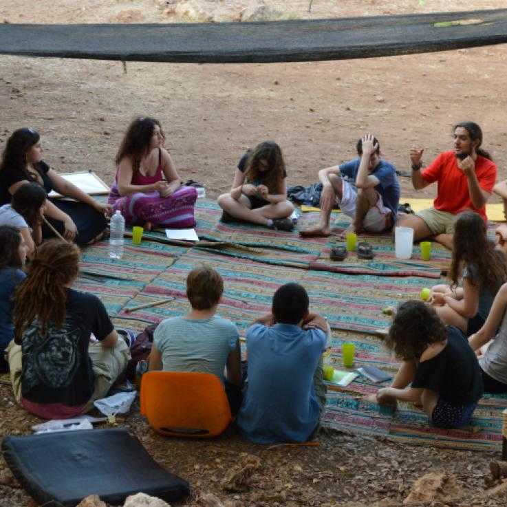 Young people sit around in a circle talking