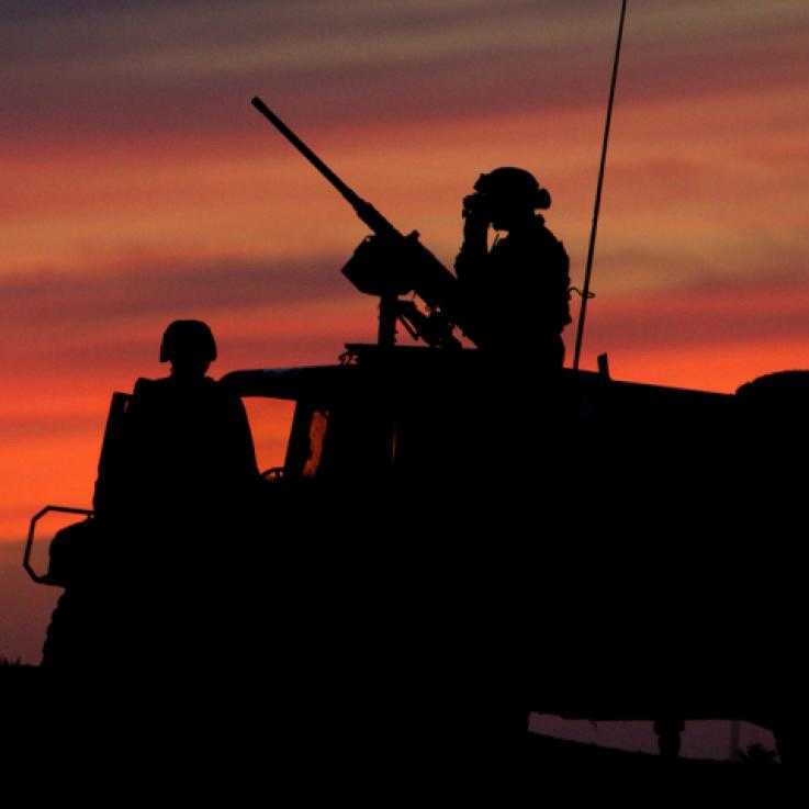 An army vehicle in Korea with soldiers in it, at sunset