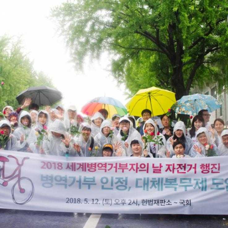 Activists in South Korea holding umbrellas and a banner