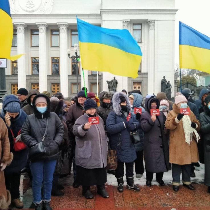 A large group of protesters stand with Ukrainian flags