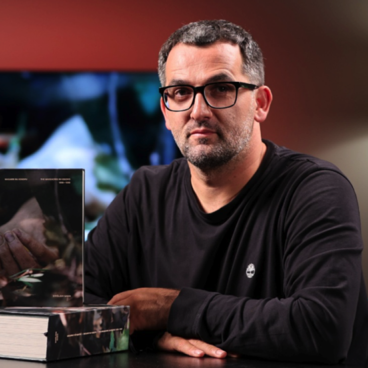 Una imagen de Shkëlzen Gashi sentado junto a su libro.